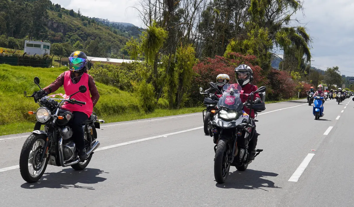 Participantes de La Ruta Rosa recorren juntos una carretera entre montañas